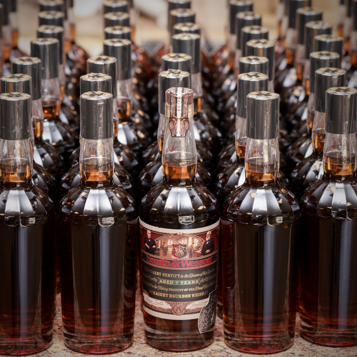 Smith & Wesson™ Classic Collection label facing bottle at the front with a collection of unlabeled bourbon in a row